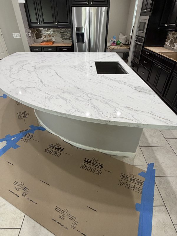Marble-look quartz island countertop being installed