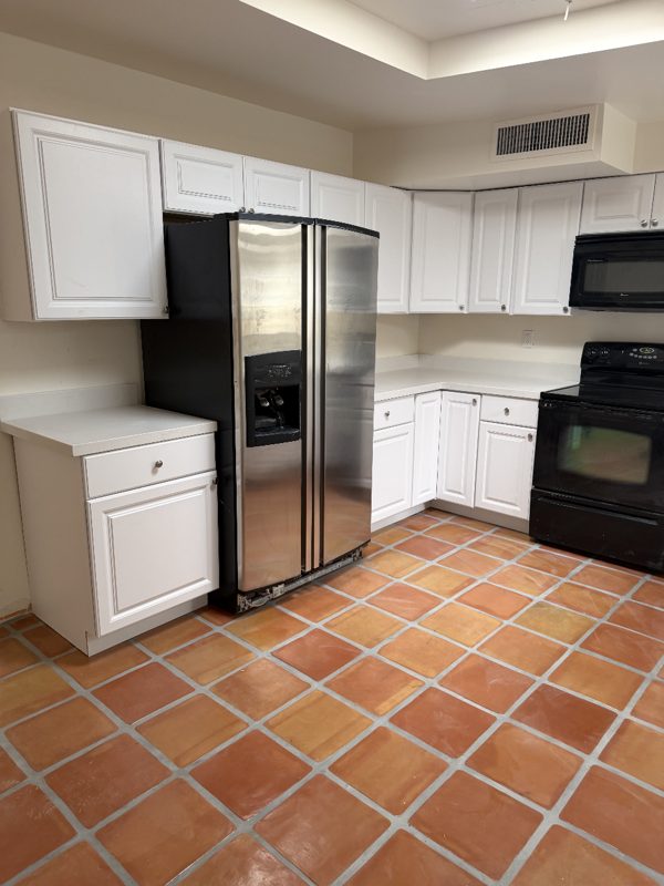 White kitchen countertop installation with saltillo tile floor